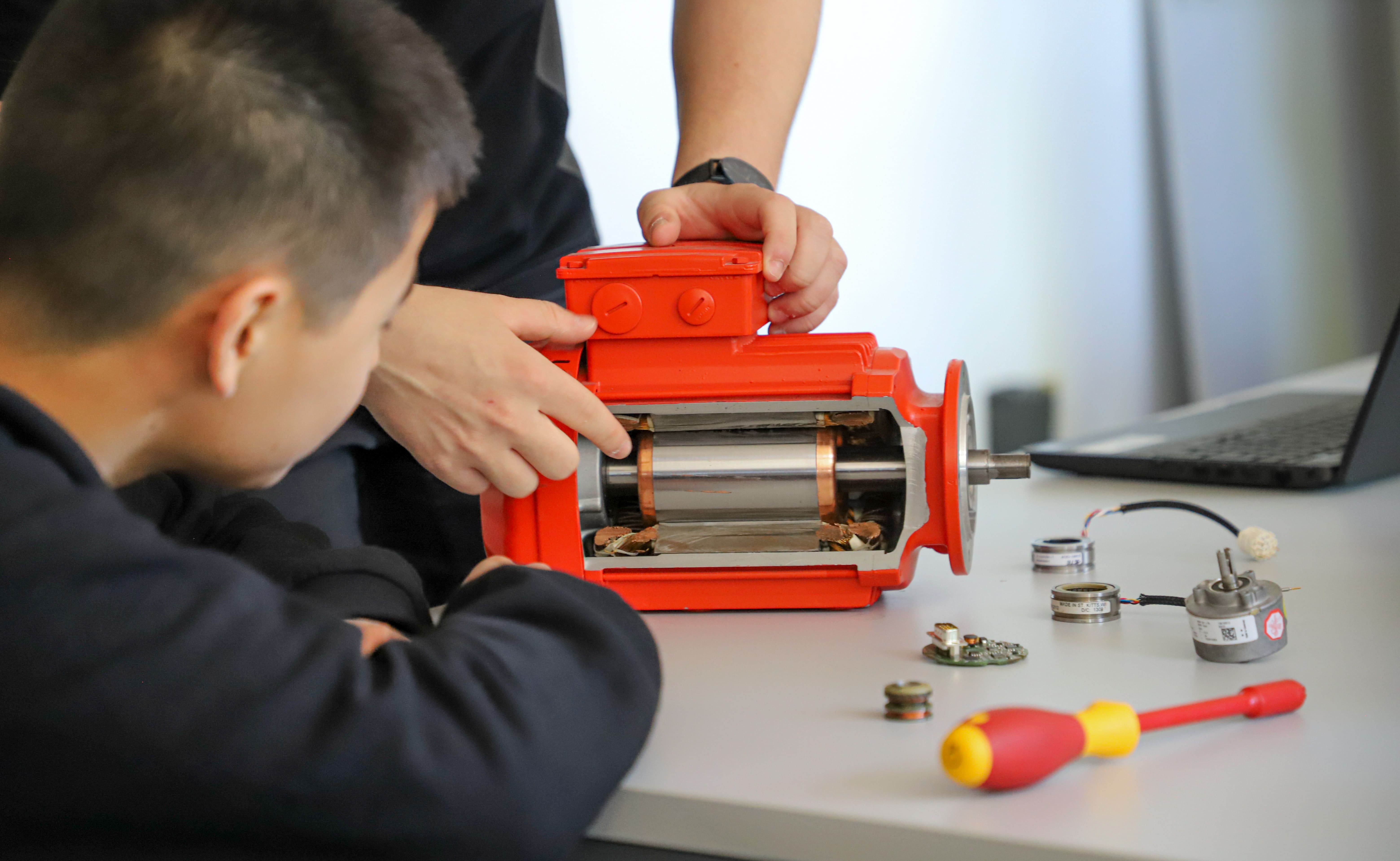Deux collaborateurs en formation technique manipulant un motoréducteur SEW USOCOME lors d’un atelier pratique